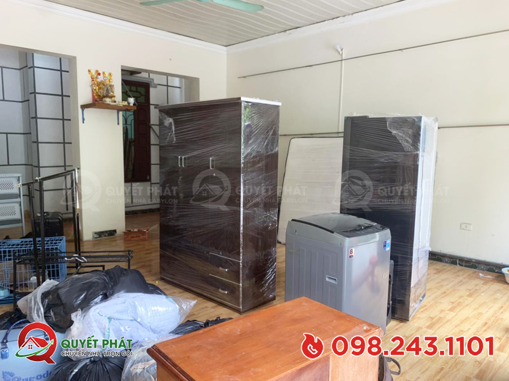 Thợ kỹ thuật tháo dỡ và quấn xốp nổ an toàn cho thiết bị điện tử gia đình.